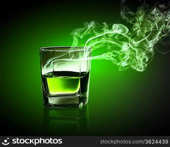 Glass of green absinth with fume going out