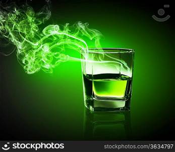 Glass of green absinth with fume going out