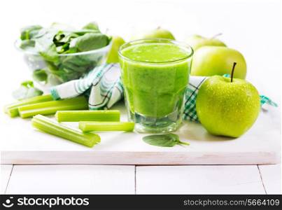 glass of green juice with apple and spinach on wooden table