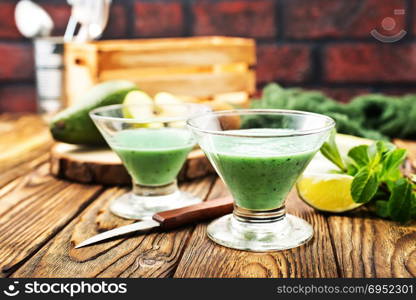 Glass of green vegetable smoothie. Green vegetable smoothie and ingredients