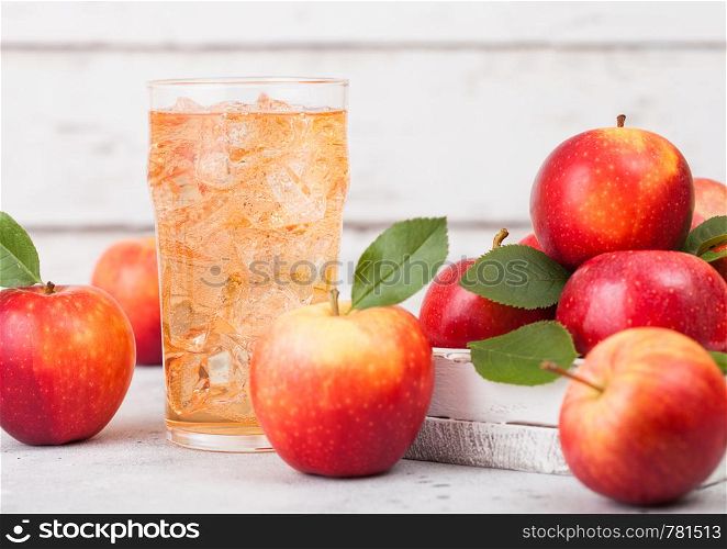 Glass of homemade organic apple cider with fresh apples in box on wooden background, Glass with ice cubes