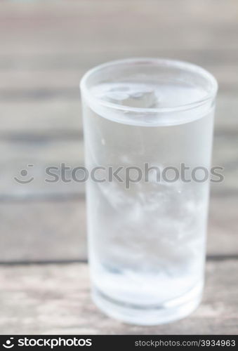 Glass of iced water on wooden table, stock photo