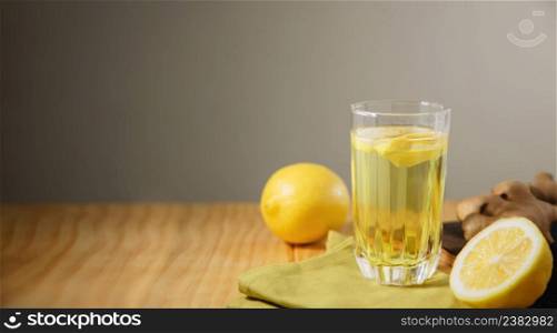 Glass of Infusion Ginger lemon drink. Organic and Healthy Lifestyle. Fresh Water with lemon Sliced. present on Table with Natural light. Seasonal Beverage