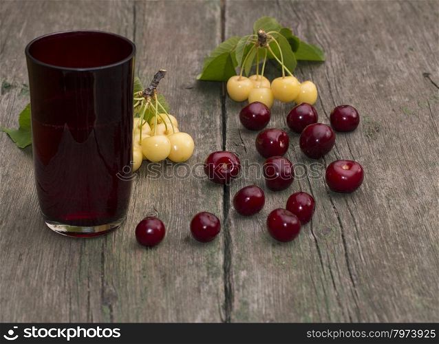 glass of juice and berry on a wooden table,