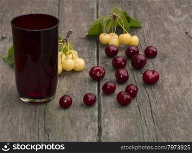 glass of juice and berry on a wooden table,