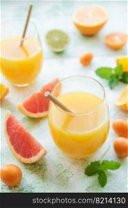 Glass of juice and fresh citrus fruits