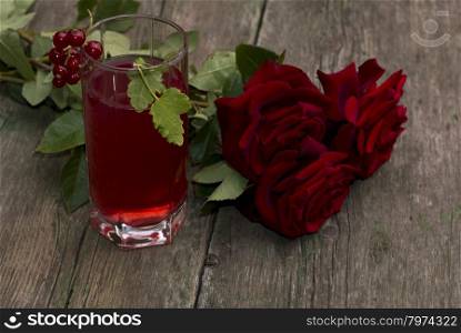 glass of juice, currant and bouquet of brightly red roses, subject drinks and flowers