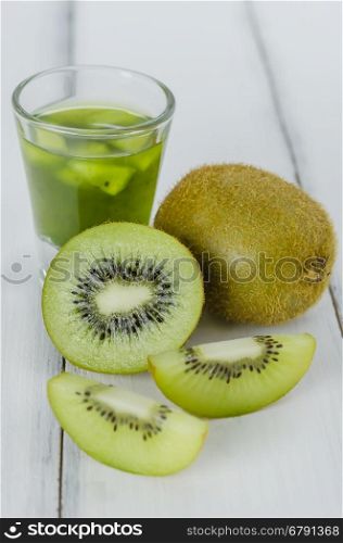 glass of kiwi juice . glass of kiwi juice with fresh fruits on wooden table