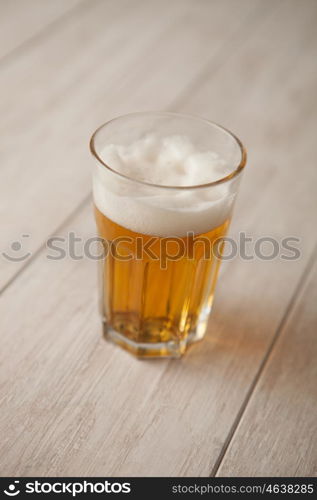 Glass of lager beer on wooden table