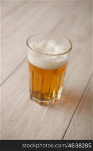 Glass of lager beer on wooden table