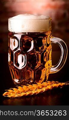 glass of lager on table against brick wall