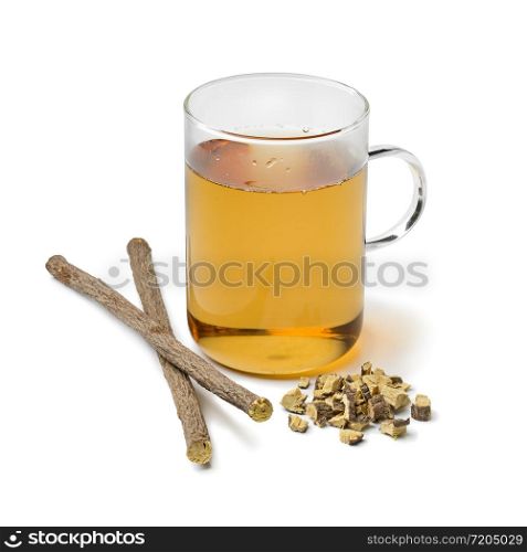 Glass of licorice tea and pieces of roots isolated on white background