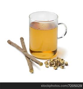 Glass of licorice tea and pieces of roots isolated on white background
