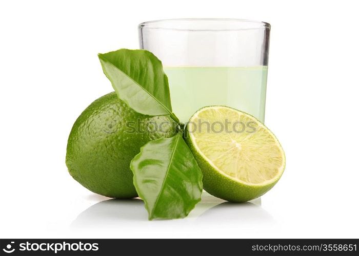 Glass of lime juice and lime fruits with green leaves isolated on white