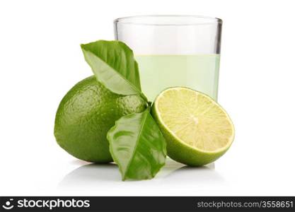 Glass of lime juice and lime fruits with green leaves isolated on white