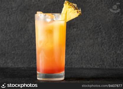 Glass of Malibu Sunset Cocktail garnished with pineapple wedge