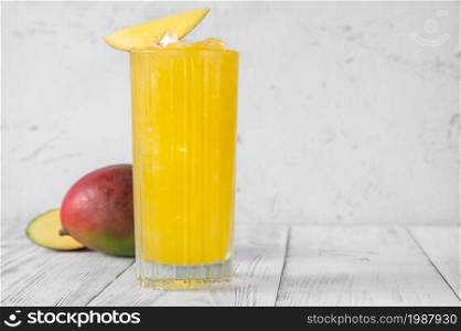 Glass of Mango Punch cocktail garnished with mango slice