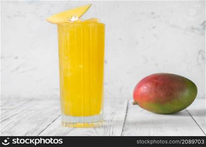 Glass of Mango Punch cocktail garnished with mango slice