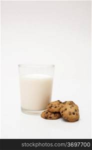 glass of milk and chocolate chip cookies on a white background