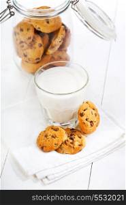glass of milk with cookies on wooden table