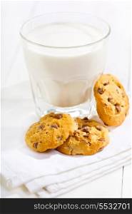 glass of milk with cookies on wooden table