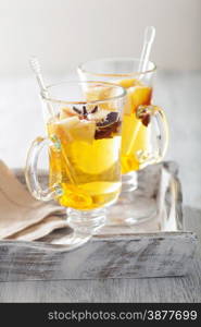 glass of mulled apple cider with orange and spices, winter drink