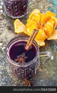 glass of mulled wine and spices. Crystal goblet with mulled wine and cinnamon stick in it