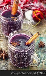 glass of mulled wine and spices. Crystal goblet with mulled wine and cinnamon stick in it