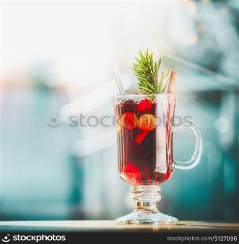 Glass of mulled wine at winter day background, front view, square
