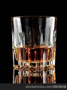 Glass of old aged cognac standing on black glass table