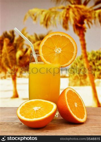 Glass of orange juice on a beach table