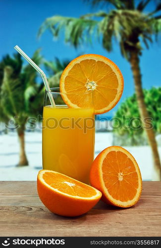 Glass of orange juice on a beach table