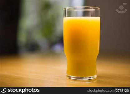 Glass of orange juice on a wooden kitchen table