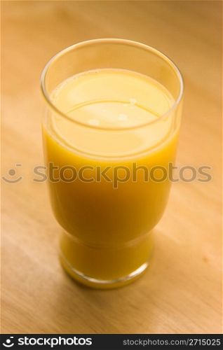 Glass of orange juice on table