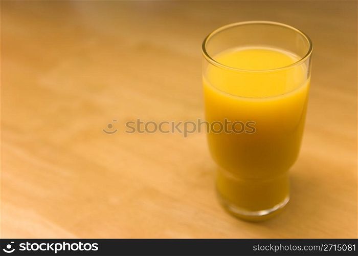 Glass of orange juice on table