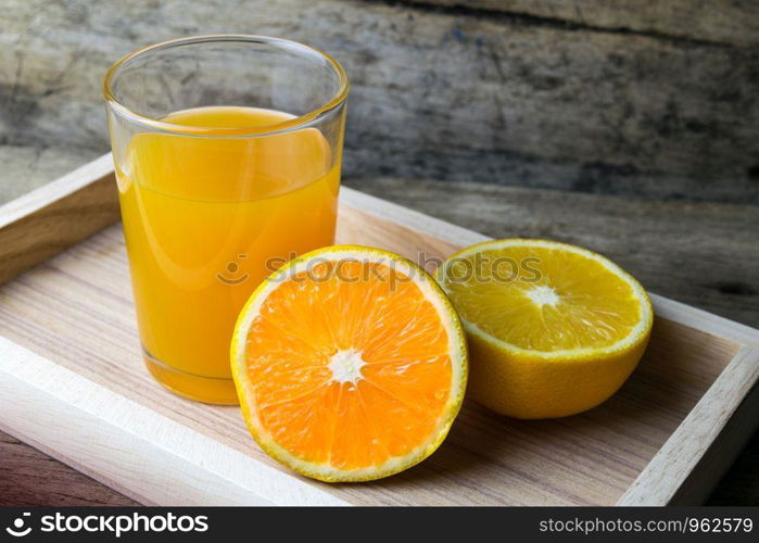 Glass of orange juice on wooden table, fresh drink