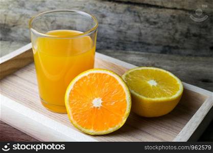 Glass of orange juice on wooden table, fresh drink