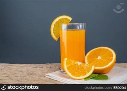 Glass of orange juice placed on wood.