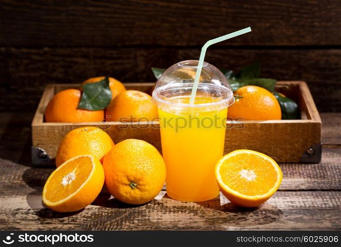 glass of orange juice with fresh fruits on wooden background