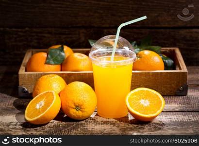 glass of orange juice with fresh fruits on wooden background