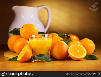 glass of orange juice with fresh fruits on wooden table