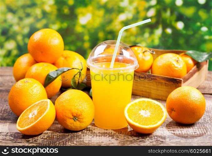 glass of orange juice with fresh fruits on wooden table