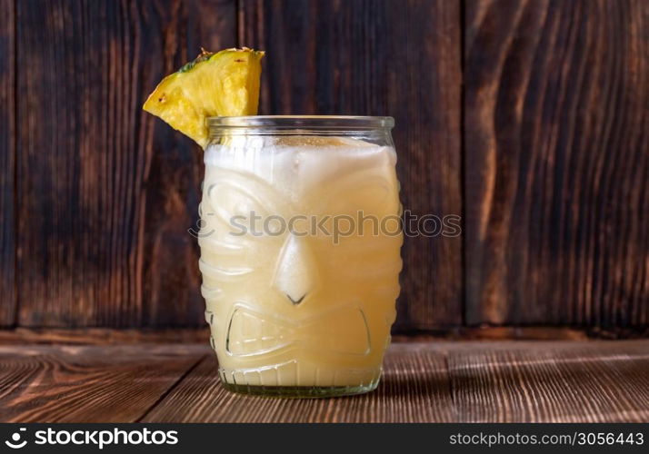 Glass of Painkiller cocktail on wooden background