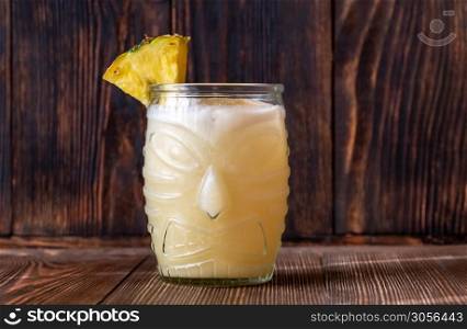 Glass of Painkiller cocktail on wooden background