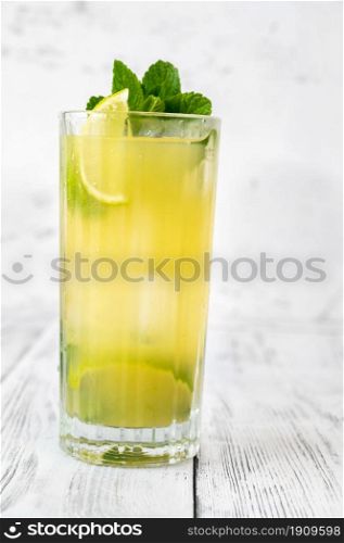 Glass of pineapple mojito on white background