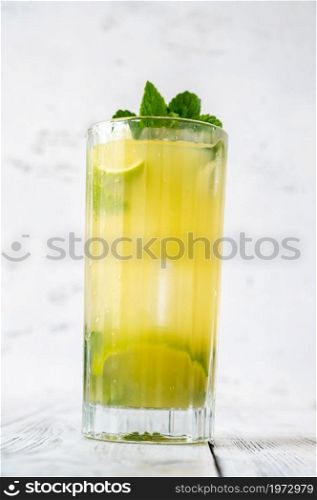 Glass of pineapple mojito on white background