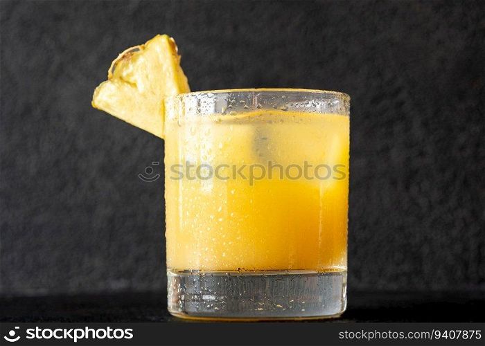 Glass of Pineapple Rum Cocktail garnished with pineapple wedge