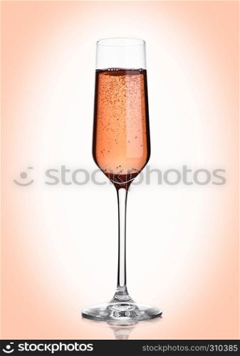Glass of pink rose champagne with bubbles on pink background