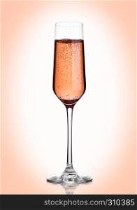 Glass of pink rose champagne with bubbles on pink background
