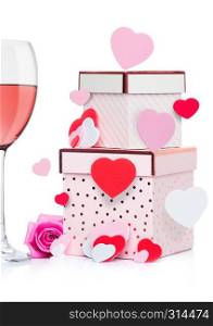 Glass of pink wine with heart and pink gift box and rose for valentine's day on white background with flying heart
